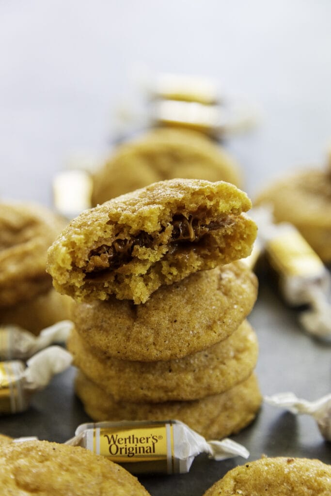 pumpkin caramel cookies stacked with one cookie with caramel showing in the middle