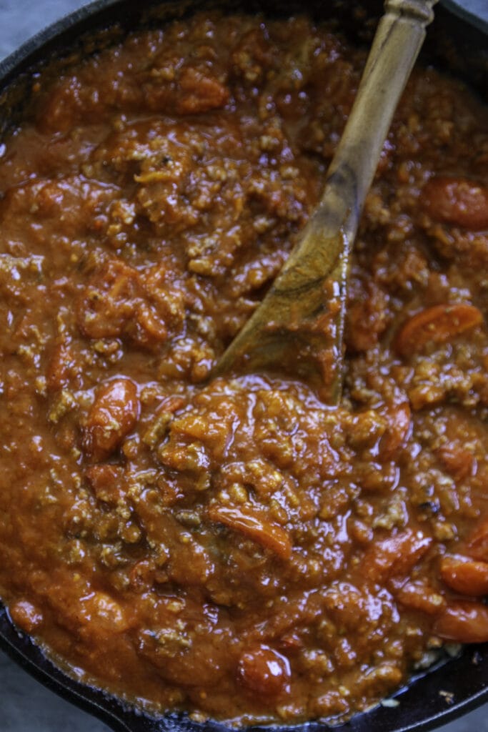 pasta sauce in skillet with wooden spoon