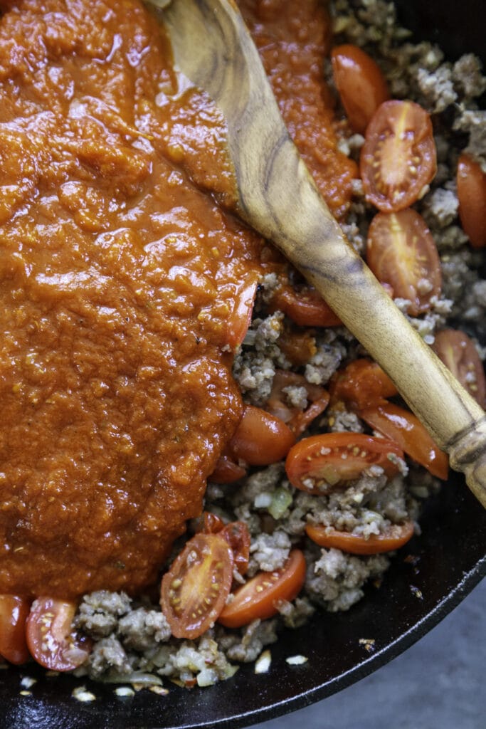 skillet with sausage tomatoes and sauce