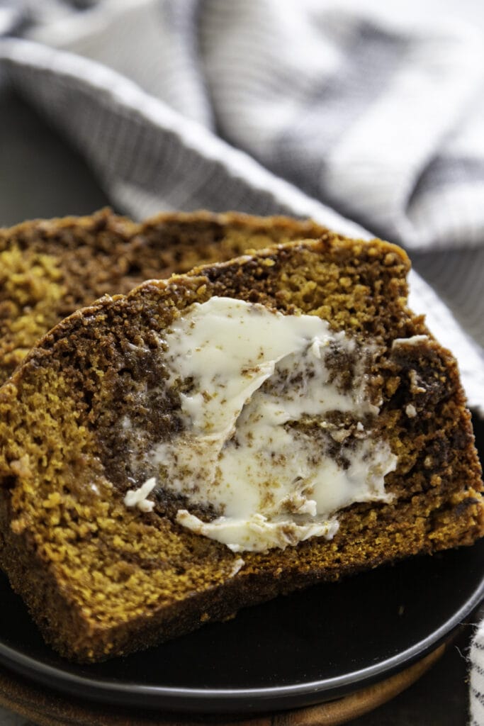pumpkin chocolate swirl bread slice on black plate with butter
