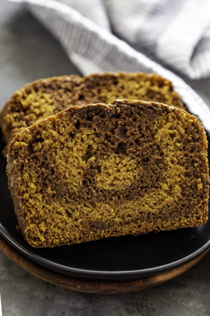 pumpkin chocolate swirl bread slice on parchment black plate