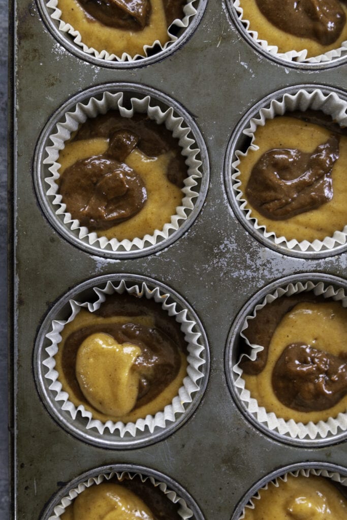overhead shot swirled muffin batter in muffin tin pan