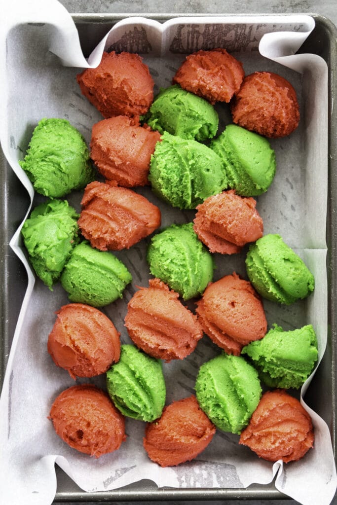 overhead shot of cookie dough both red and green in 9x13 baking pan
