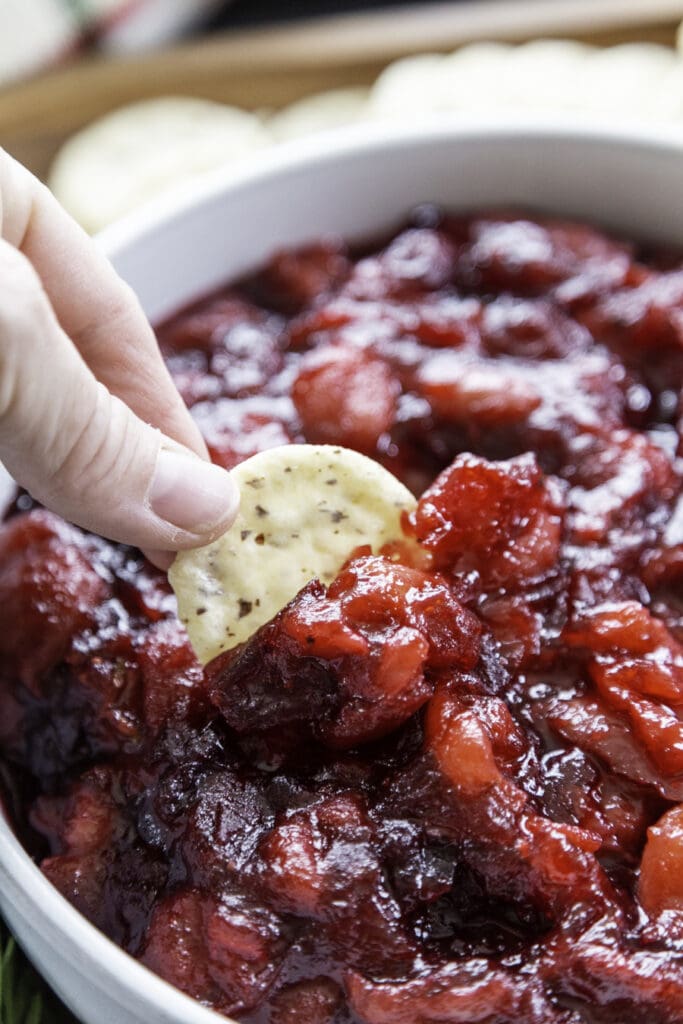 dipping cracker in cranberry compote