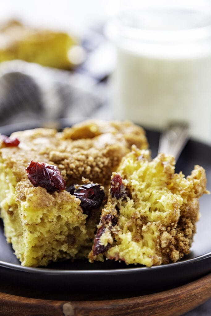 piece of cranberry orange coffee cake on plate bite out of it
