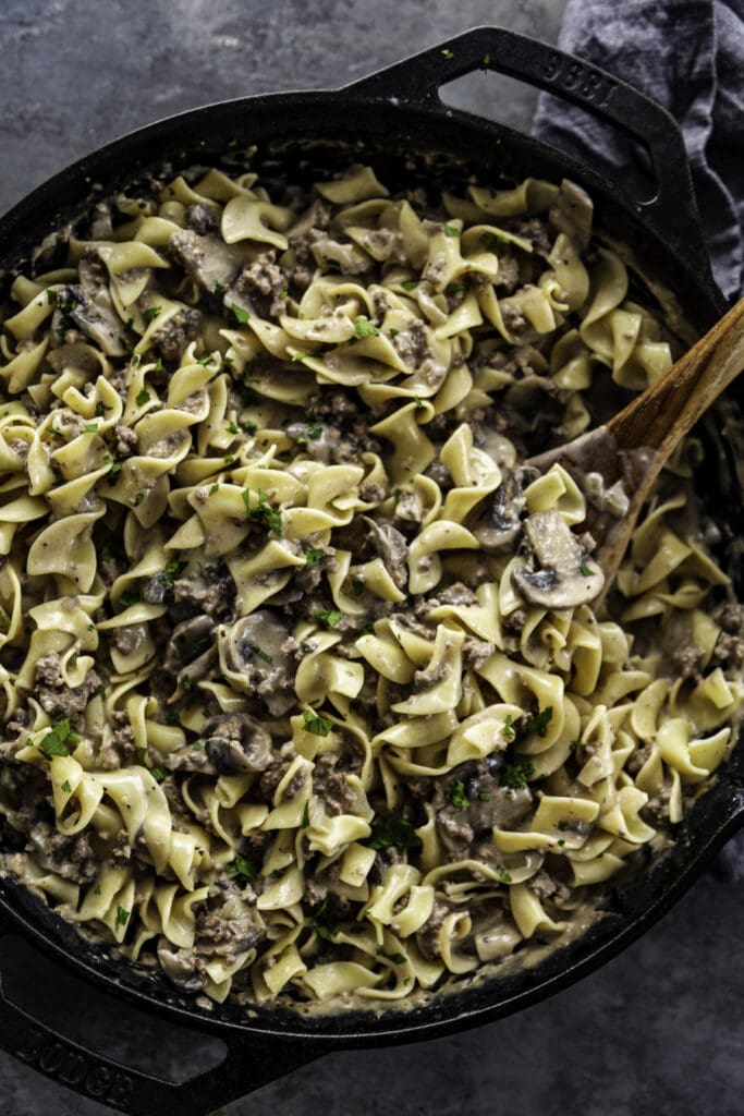overhead shot of beef stroganoff with wooden spoon