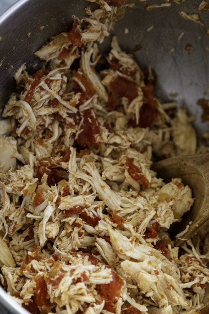 shredded chicken and tomatoes in mixing bowl