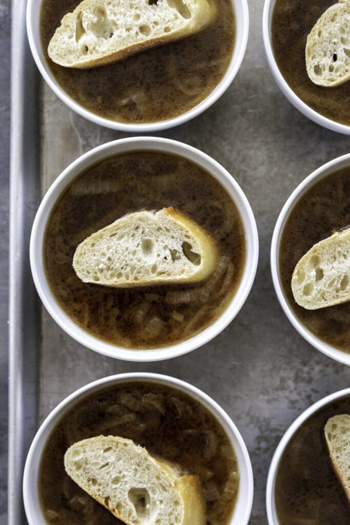 small bowls with onion soup and piece of bread on top