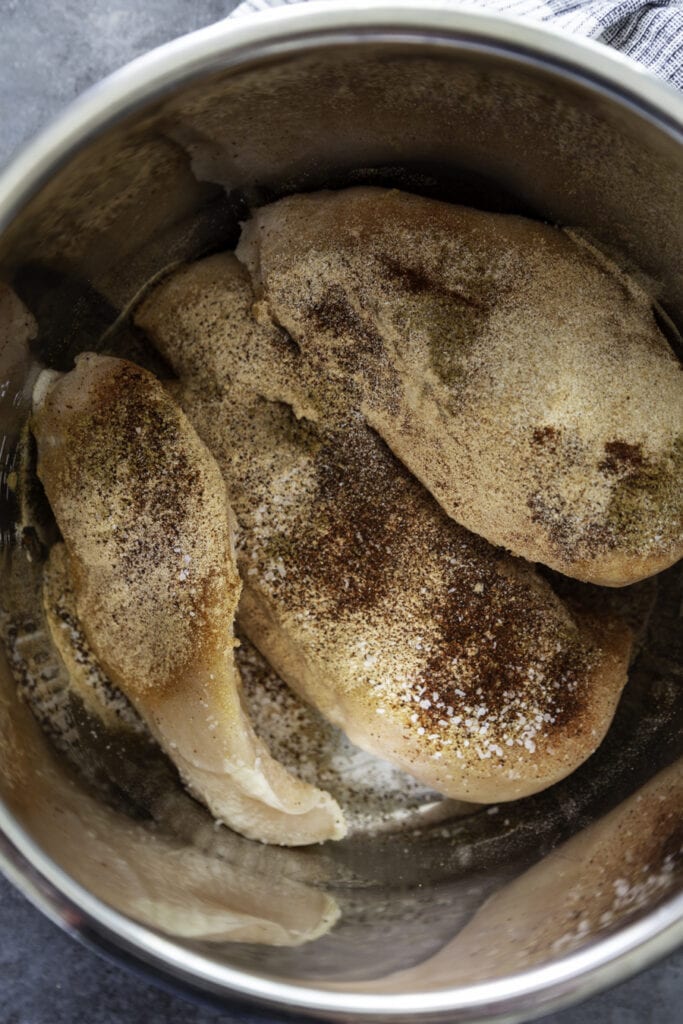 overhead shot of chicken in seasonings sprinkled over them