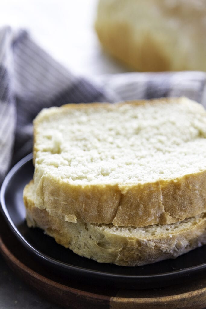 two slices of homemade white bread on black plate