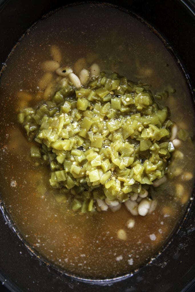 green chiles in slow cooker over white beans
