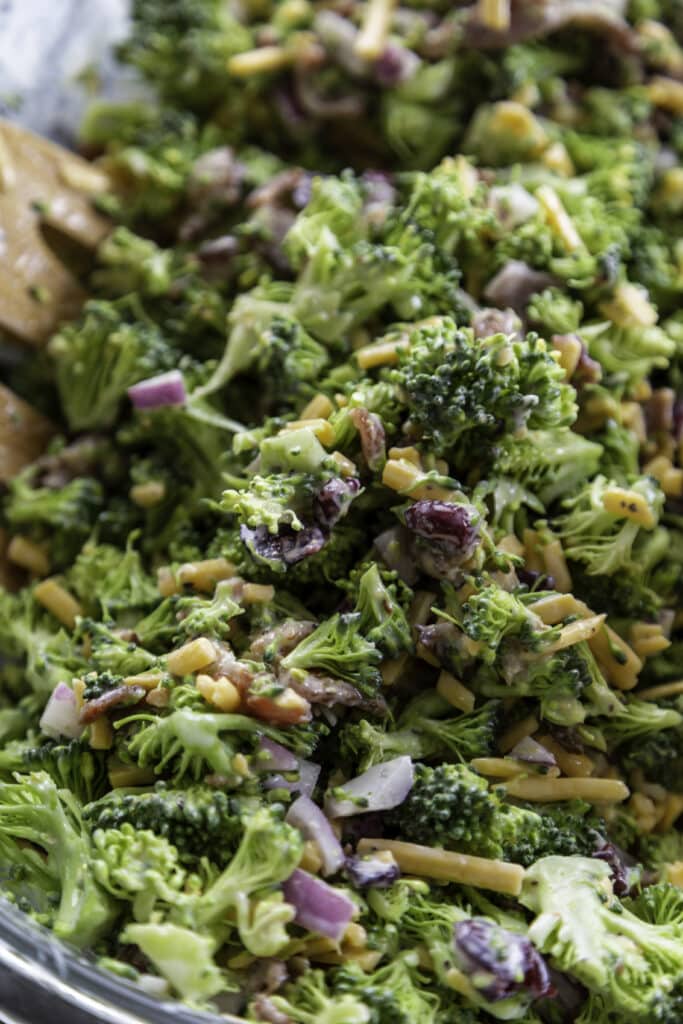broccoli salad with bowl and wooden tongs