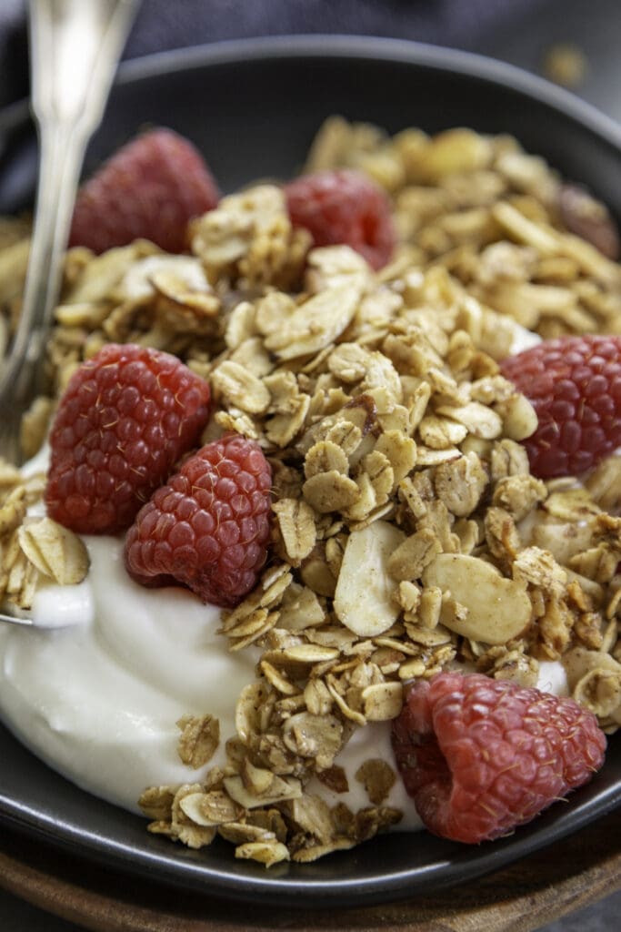 granola on plate over yogurt with berries