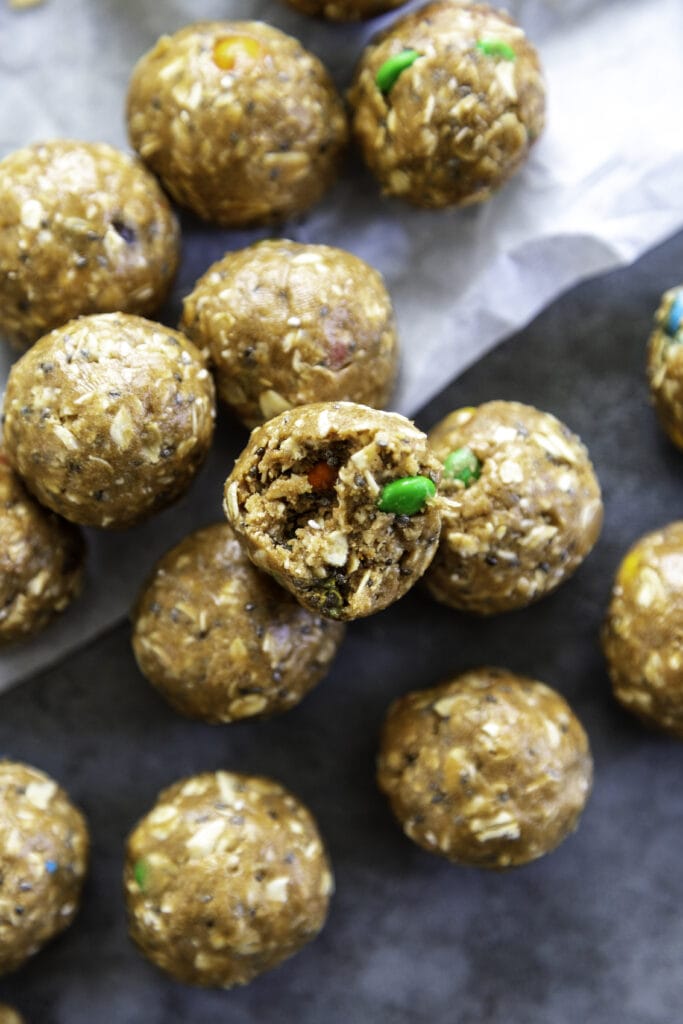 overhead shot of peanut butter protein balls with m&ms with bite out of one