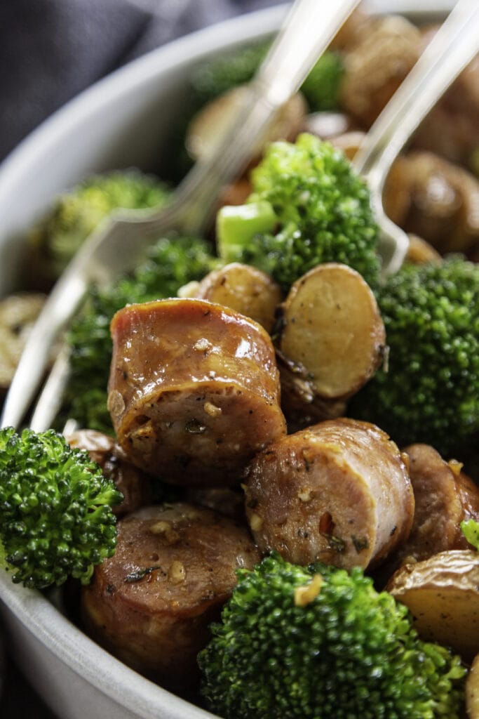 broccoli, potatoes and sausage in a bowl with fork close up shot