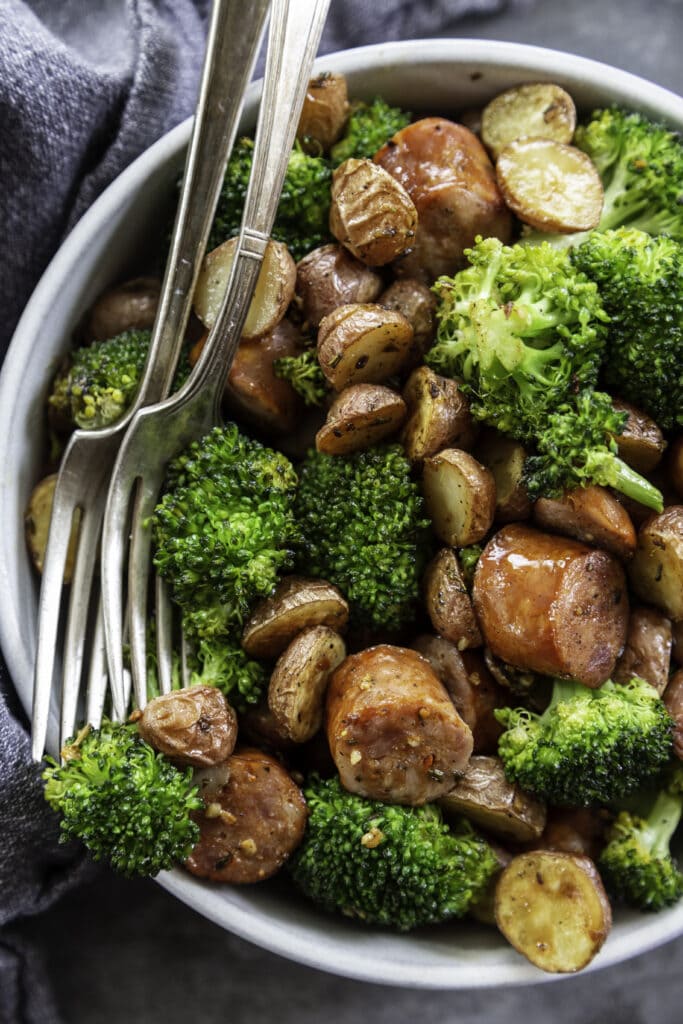 overhead shot of broccoli, potatoes and sausage in a bowl