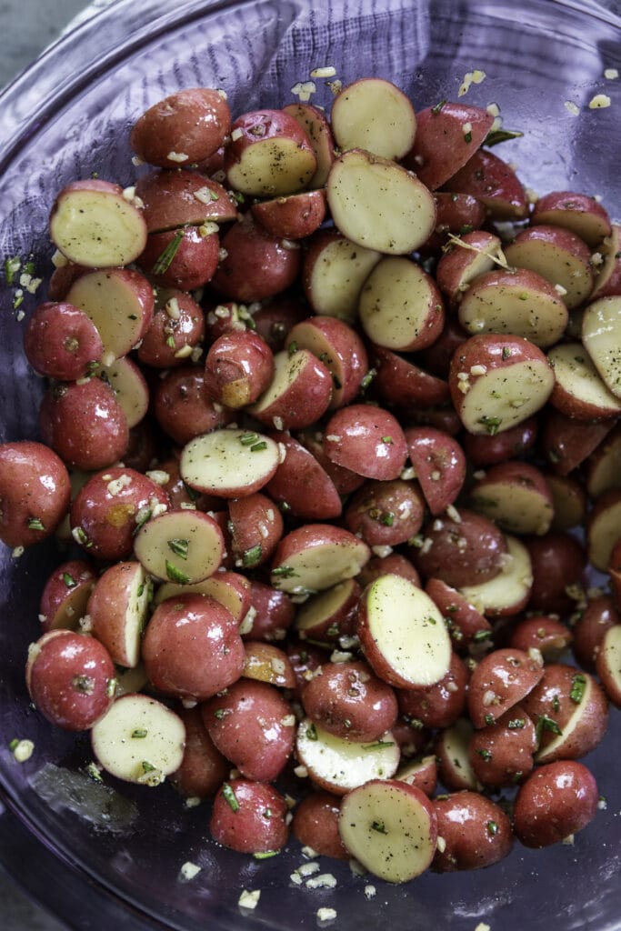 overhead shot of bowl with potatoes and olive oil and seasonings