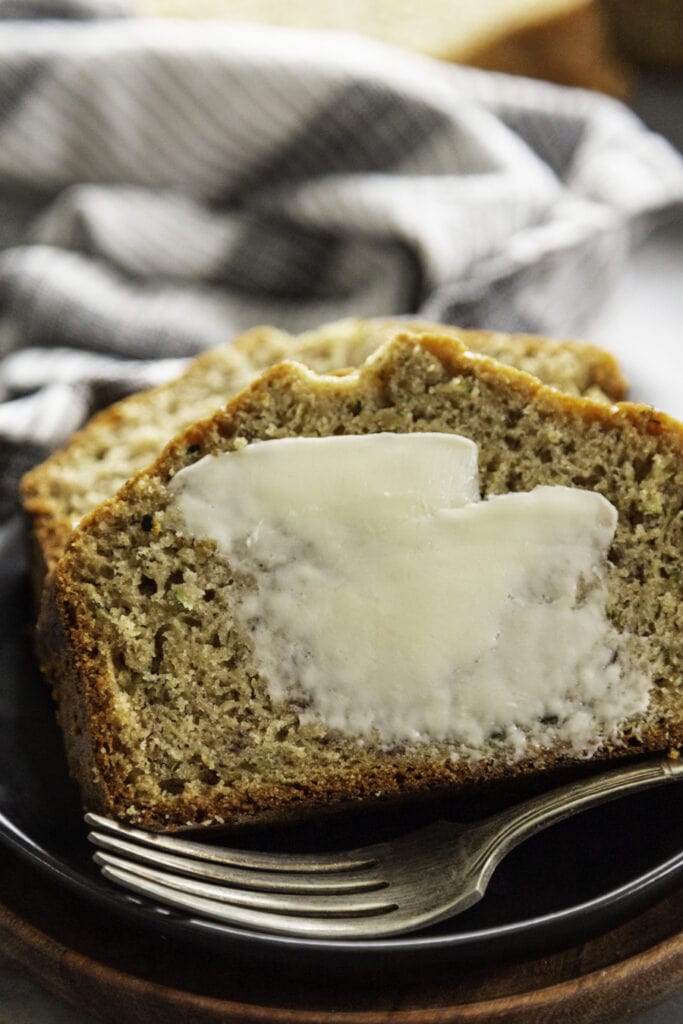 loaf of zucchini banana bread sliced with butter