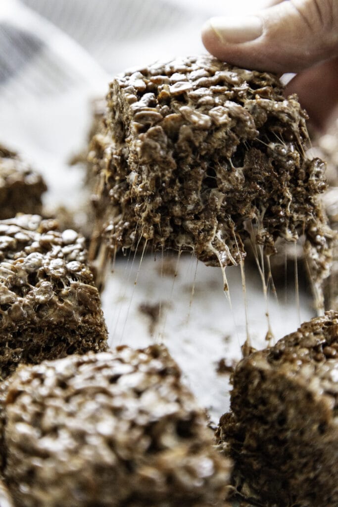 chocolate rice krispie treat pulled away with gooey marshmallow strands