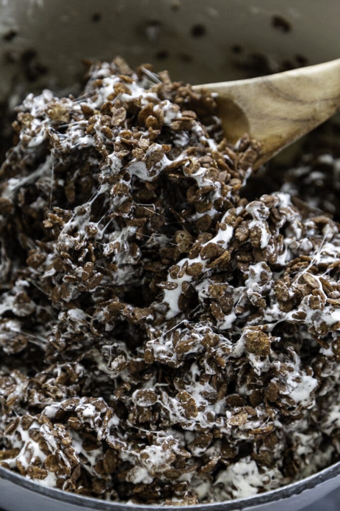 pot with melted marshmallows with cocoa rice krispies being mixed in