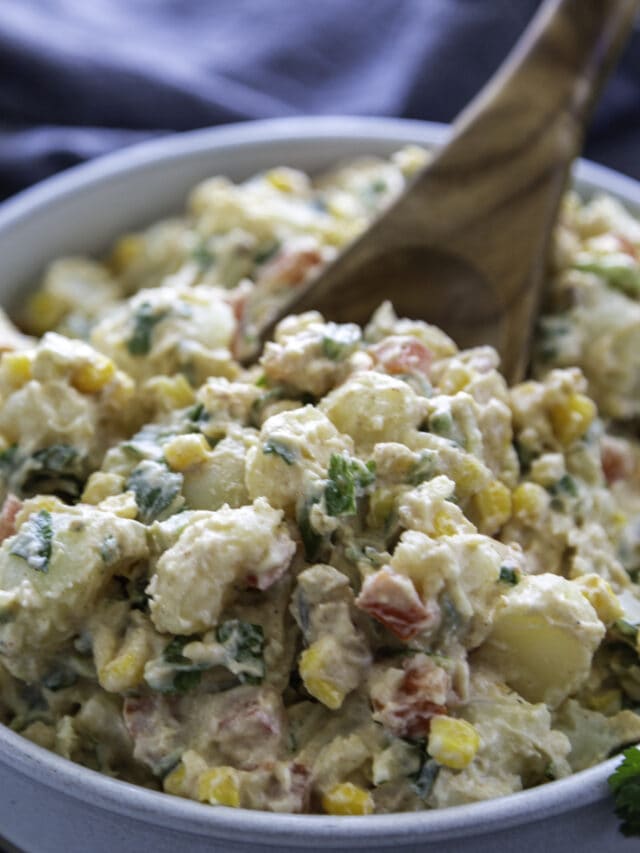 southwest potato salad in serving bowl with wooden spoon