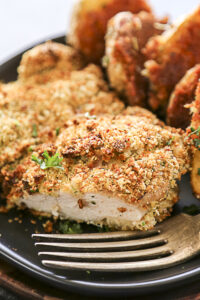 chicken with fork on black plate cut