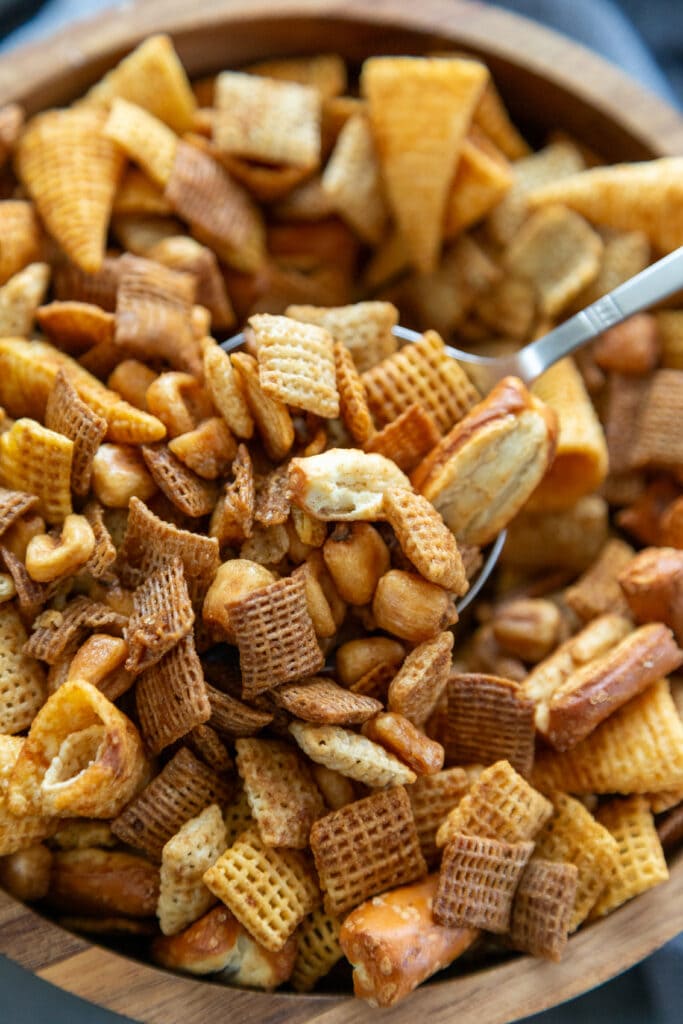 wooden bowl of chex mix with serving spoon