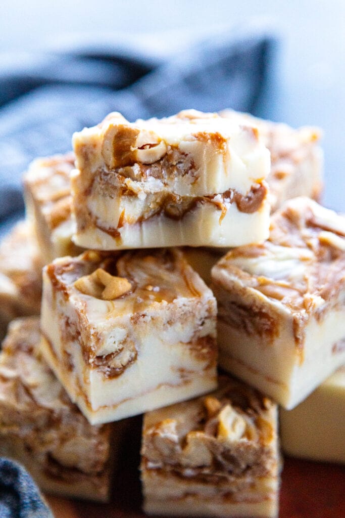 stack of white chocolate caramel and cashews fudge with bite out of one piece