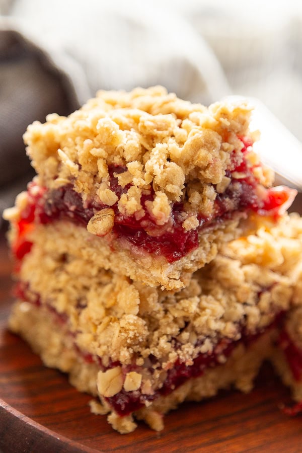 cherry oat bars stacked on wood plate