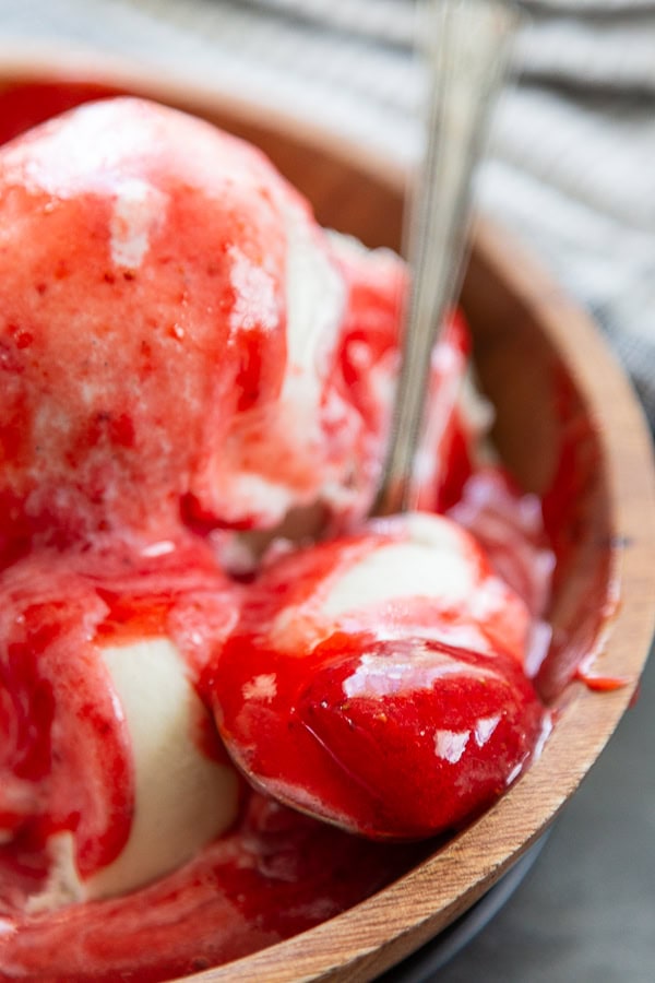 spoon full of ice cream with strawberry sauce