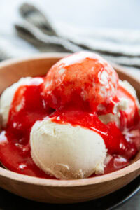strawberry sauce over vanilla bean ice cream in bowl