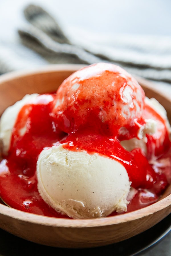 strawberry sauce over vanilla bean ice cream in bowl