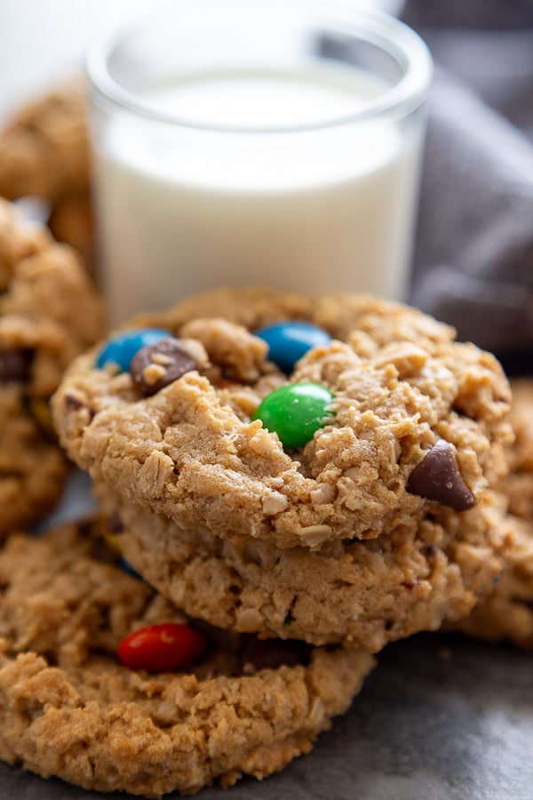 stack of monster cookies by glass of milk