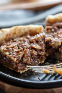 2 slices of chocolate pecan pie with bite take out